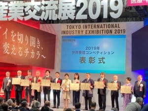 産業交流展 2019 の世界発信コンペティション表彰式で、受賞者が壇上に並んだ記念撮影